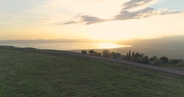 İsrail 'in kuzeyindeki Golan Tepeleri ve Taiberia' da günbatımında hava görüntüleri. Turuncu yeşil manzaralı açık alanlar ve Celile denizi üzerindeki dağlar veya Ürdün vadisinde Kinnert 