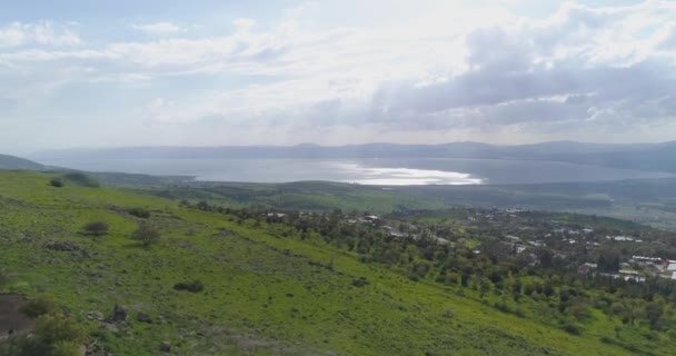Zdjęcia lotnicze nad wzgórzami Golan i Taiberia w północnym Izraelu. Otwarte pola z zielonymi krajobrazami i górami nad morzem Galilejskim lub Kinnert w dolinie Jordanu — Wideo stockowe