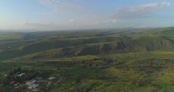 イスラエル北部のゴラン高原とタイベリア上空で空中撮影。ガリラヤ湖の上の緑豊かな風景と山々、またはヨルダン渓谷のキンナントとオープンフィールド — ストック動画