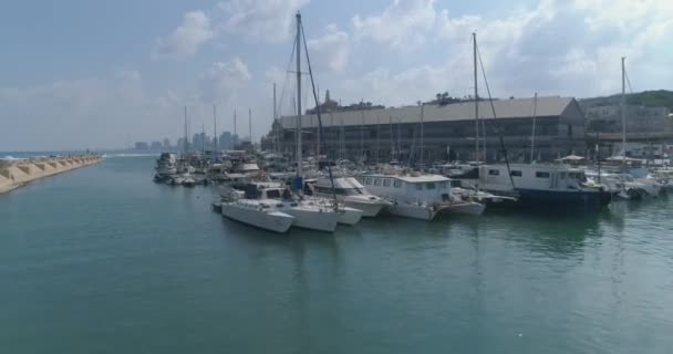 Légi kilátás a kikötői öböl felett, csónakokkal és jachtokkal Parkoló vagy kikötve. Mediterrán turizmus Utazás lövés Tel aviv Jaffa a háttérben — Stock videók