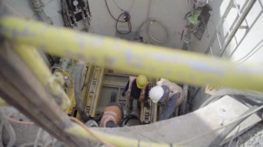 Heavy Industry mühendisleri inşaat alanında beton boruların içinde çalışarak yapı borularını tamir ediyorlar. Endüstriyel İmalat İnşaat 'ta kask ve üniforma giyiyor.