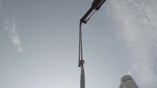 금속 강철 크레인 이 콘크리트 튜브나 파이프를 들고 하늘을 향해 들어올리고 있습니다. 건축 현장에서 찍은 사진. — 비디오