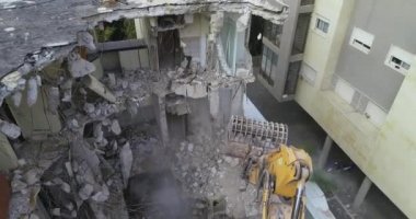 Kazıcı Beton Duvarı Yok Ediyor. Excavator 'un yukarısındaki hava görüntüleri şehrin merkezindeki eski apartmanı yok ediyor ve yıkıyor.