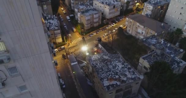 Moderne graafmachine bulldozer en schop met grote cutter vernietigt gebouw gevel in het midden van woonwijk omgeven door appartementen gebouwen 's nachts. — Stockvideo