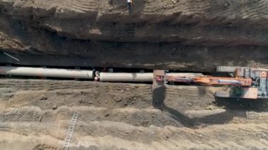 Ulusal altyapı kanalizasyon sistemine su boru hattı döşemek için kum toprağı kazan traktör. Açık hava inşaat işyeri projesinde hava aracı