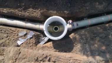 Beton boru tesisatı. Dışarıdaki adamların üzerindeki hava, kazma topraklarına su veya kanalizasyon boru hattı bağlamak ve kurmak için ağır makinelerle çalışıyor.