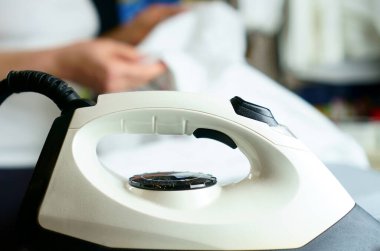 Beyaz ütülü beyaz elbiseleri ütüleyen kadın: evinde, çamaşırhanede