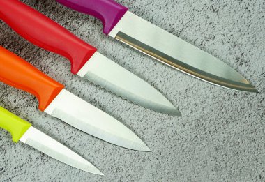Çok renkli mutfak bıçakları: kırmızı, bordo, turuncu, sarı