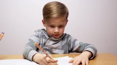 Not defterine çizim ve yazım yapan mutlu çocuk. Beyaz çocuk konsantre olur, düşünür ve çalışır. Ödev yapıyorum..