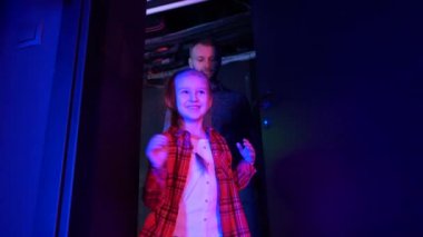 Futuristic concept: family with child amazed by augmented reality technology and vr video games. Happy family enjoying virtual reality game room. Exploring together