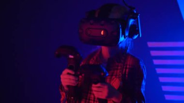 Futuristic concept: Close up girl using augmented reality equipment. Adult enjoying virtual reality video head set. Playing video games in vr. Futuristic RGB lights