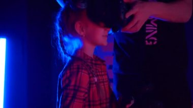 Futuristic concept: Close up girl using augmented reality equipment. Adult enjoying virtual reality video head set. Playing video games in vr. Futuristic RGB lights