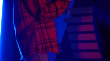 Futuristic concept: Close up girl using augmented reality equipment. Adult enjoying virtual reality video head set. Playing video games in vr. Futuristic RGB lights