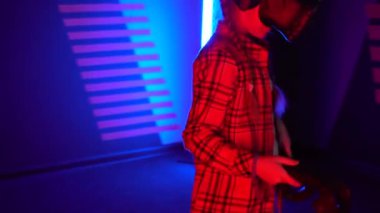 Futuristic concept: Close up girl using augmented reality equipment. Adult enjoying virtual reality video head set. Playing video games in vr. Futuristic RGB lights