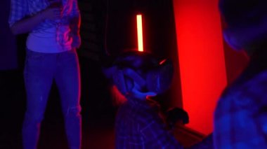 Futuristic concept: girl and family using augmented reality head set and controllers. Friendly team cheering and supporting while she is using virtual reality equipment