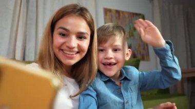 Güzel anne ve oğul evde selfie çekiyorlar. Mutlu aile görüntülü görüşme yapıyor. Birlik, bağlantı, teknoloji kavramı