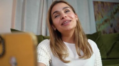 Görüntülü aramada gülümseyen güzel bir melez kadın. Yaşam stili vlogger canlı yayın videosu. Yakışıklı kadın konuşuyor ve gülüyor..