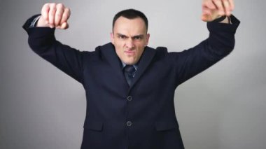 Takım elbise ve kravat giyerken tezahürat ve çığlık atan yakışıklı iş adamı. Takım elbiseli kızgın adam çıldırıyor. Ofis görevlisi bağırıyor çünkü kazandı ya da kaybetti..