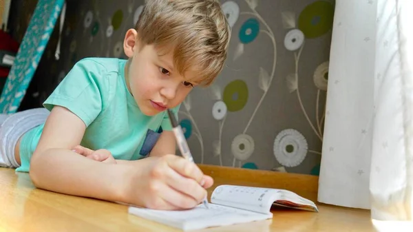 Çocuk Konsantre Oluyor Düşünüyor Çocuk Ödevlerini Yapıyor Defterine Yazı Yazıyor — Stok fotoğraf