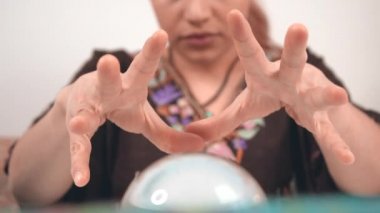 Kristal küreye bakıyorum. İlahi güçlere sahip mistik kadın ilahi söylüyor. Kristal kullanan otantik falcı. Okültizm ve paranormal aktivite kavramı.