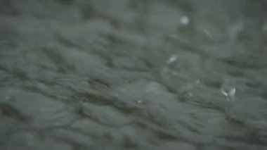 Su damlaları suya damlıyor. Yağmur makrosu yakın çekim.