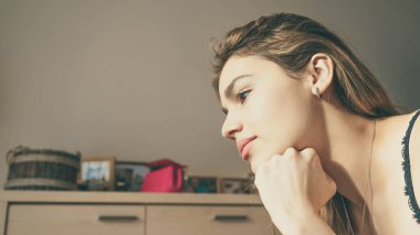 Yakışıklı melez bir kadın. Yatakta sörf yapan güzel bir kadın. Portre fotoğrafı. Sıradan gülümseme ve şirinlik. Sıcak ve güneşli atmosfer