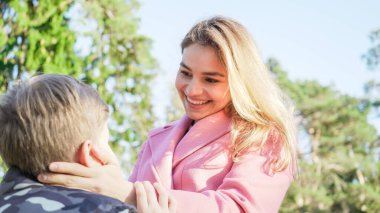 Güzel anne ve oğul birbirlerini seviyorlar. Anne ve oğul doğada gülerek ve gülerek birbirlerinin gözlerinin içine bakarlar. Doğada güneşli bir gün. Aile birliği kavramı. 