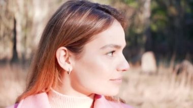 Güzel genç bayan gülümseyen kameraya bakıyor. Yakışıklı bir kız gülüyor. Açık havada doğa portresi çekimleri.. 