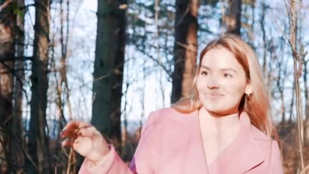 美しい笑みを浮かべて女性の森の中の木の枝を歩く 太陽と森を楽しむ屋外の魅力的なスタイリッシュな女の子 — ストック動画