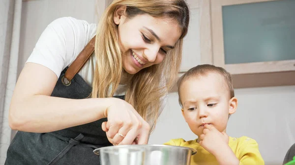 Anne ve oğlu mutfakta birlikte yemek hazırlıyorlar. Mutlu aile yemekleri ve eğlenmeleri. Ev etkinliği ve eğitim kavramı. 