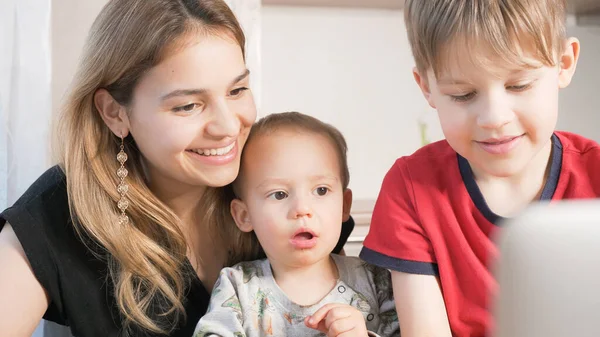 Güzel bir anne ve çocukları bilgisayar başında bir video görüşmesi yapıyorlar. Mutlu aile yüz yüze konuşmanın keyfini çıkarıyor.. 