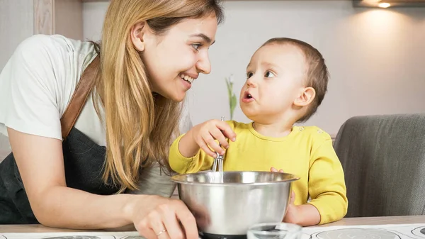 Anne ve oğlu mutfakta birlikte yemek hazırlıyorlar. Mutlu aile yemekleri ve eğlenmeleri. Ev etkinliği ve eğitim kavramı. 