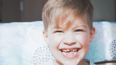 Şirin çocuk gülüyor ve surat yapıyor. Güzel çocuk portresi