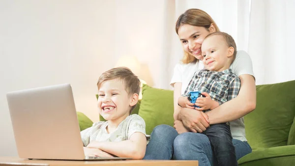 Beautiful mom with sons having a facetime video call. Happy family taking selfies and video chatting at home. Mother\'s day, unity, connection concept.