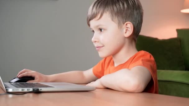コンピュータを使って頭のいい優しい少年 子供は自宅でコンピューターを勉強して学びます 家庭教育の概念 幸せと笑顔の子供がビデオゲームをプレイ — ストック動画