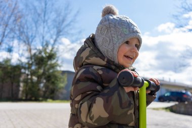 Güneşli bir günde parkta gülümseyen bir çocuğun portresi..