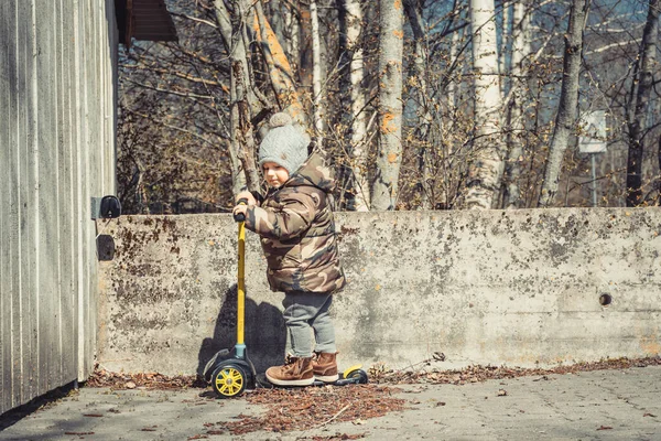 Güneşli bir günde scooter süren sevimli mutlu çocuk..