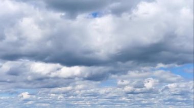 Mavi gökyüzünde uçan beyaz kümülüs bulutlarının havadan hızlanması. Tepenin tepesinden gökyüzü güzel görünüyor.