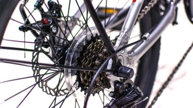 Close up wheel and chain of mountain biking. Landscape view of disc break system and front Derailleur of moutain bike. bicycle parts titanium color and frame aluminium. Shift lever and brake lever.