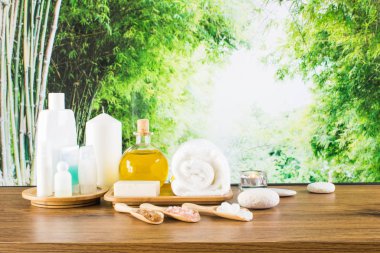 Close up of beauty and fashion concept with spa setting for wellness center. Beautiful composition of spa cosmetic products concept, massage and aromatherapy oil in bamboo forest with light & bokeh
