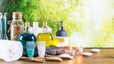 Close up of beauty and fashion concept with spa setting for wellness center. Beautiful composition of spa cosmetic products concept, massage and aromatherapy oil in bamboo forest with light & bokeh