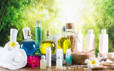 Close up of beauty and fashion concept with spa setting for wellness center. Beautiful composition of spa cosmetic products concept, massage and aromatherapy oil in bamboo forest with light & bokeh
