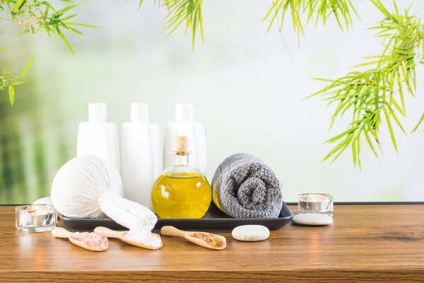 Close up of beauty and fashion concept with spa setting for wellness center. Beautiful composition of spa cosmetic products concept, massage and aromatherapy oil in bamboo forest with light & bokeh