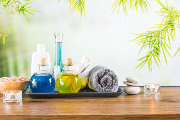 Close up of beauty and fashion concept with spa setting for wellness center. Beautiful composition of spa cosmetic products concept, massage and aromatherapy oil in bamboo forest with light & bokeh