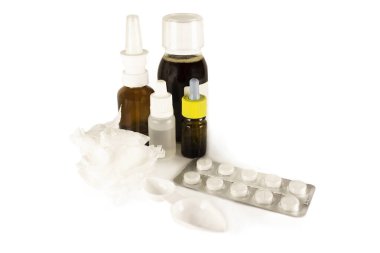 Treatment of colds and flu. Various medications, cold pills, throat spray, nasal drops, and a paper napkin on a white background. Treatment of influenza. Copy space.Medicine flat lay.