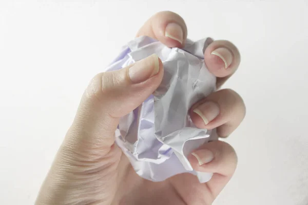 La mano de una mujer sostiene una bola de papel arrugada con una copia del espacio sobre un fondo gris. Papel arrugado en mano, mano y papel arrugado, sobre fondo blanco — Foto de Stock