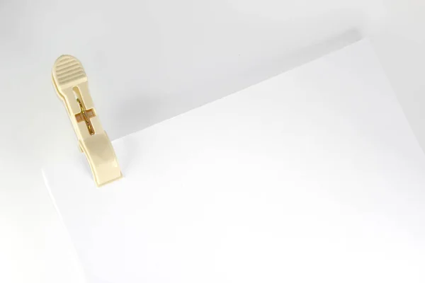 Plastic clothespin and blank paper on white background. Close up of blank paper with plastic clothespin performing the role binder clip. — Stock Photo, Image