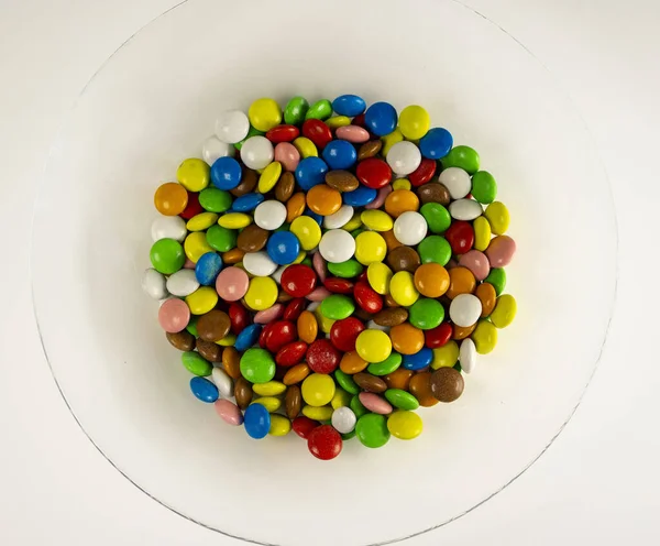 Un plato de gominolas multicolores sobre fondo blanco. La decoración del fondo. De cerca. —  Fotos de Stock