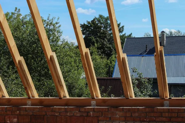 Roof trusses not covered with ceramic tile on a detached house construction, visible roof elements, battens, counter battens, rafters. Industrial roof system with wooden timber, beams and shingles