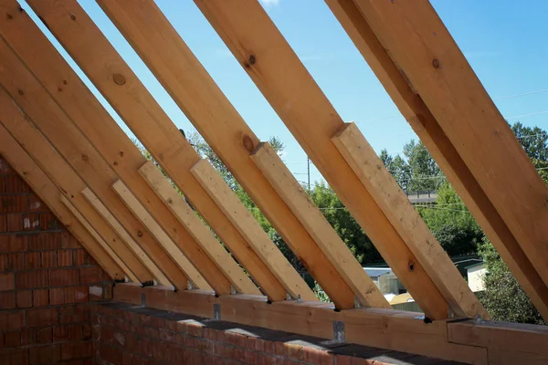 Roof trusses not covered with ceramic tile on a detached house construction, visible roof elements, battens, counter battens, rafters. Industrial roof system with wooden timber, beams and shingles.